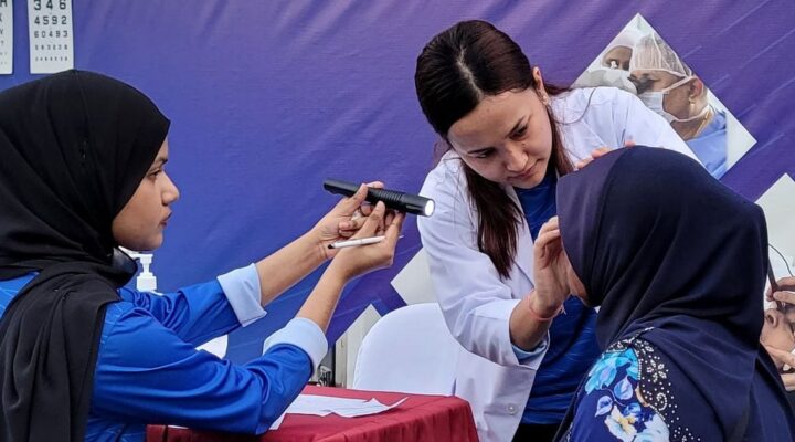 EyeCare Hospital doctor examining an elderly woman's eyes at Israhvehinge Ufaa, Vilingili